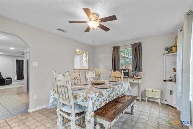 4103 Koala Dr, Killeen, TX 76543 - dining room with tile patterned floors, a textured ceiling, visible vents, ceiling fan, and arched walkways