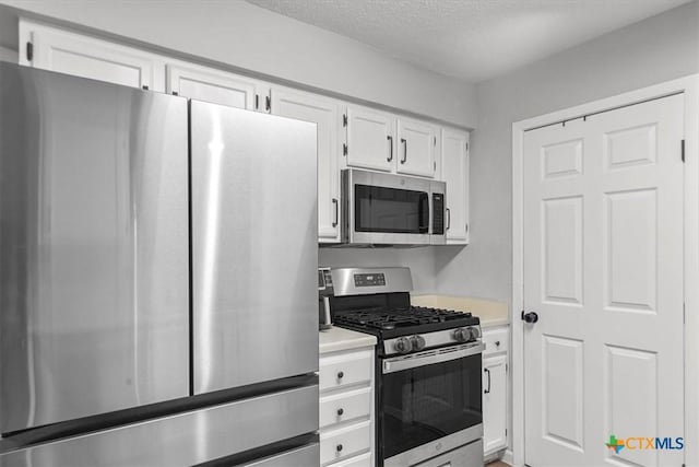 4103 Koala Dr, Killeen, TX 76543 - kitchen with white cabinets, light countertops, a textured ceiling, and stainless steel appliances