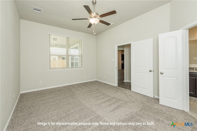 unfurnished bedroom with light carpet, ceiling fan, and ensuite bath