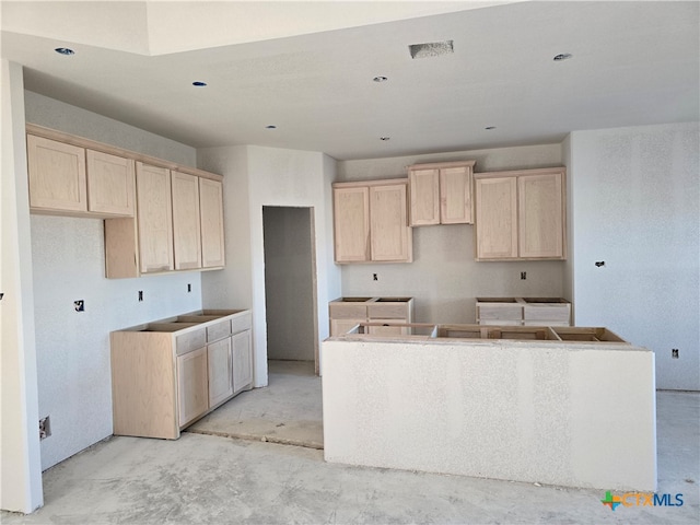 kitchen with a center island and light brown cabinetry