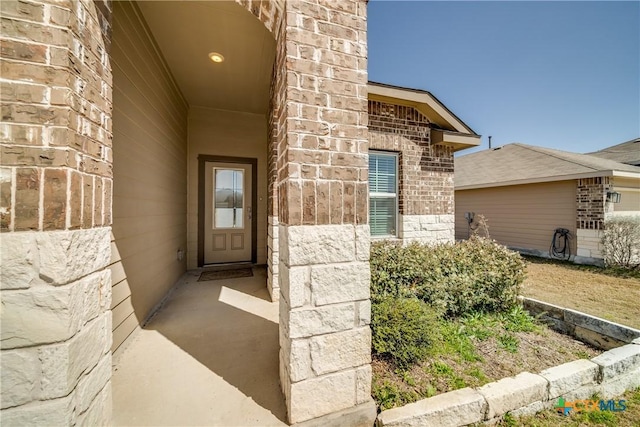 view of exterior entry featuring brick siding