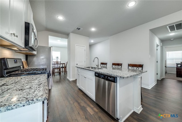 kitchen featuring backsplash, visible vents, stainless steel appliances, and a sink