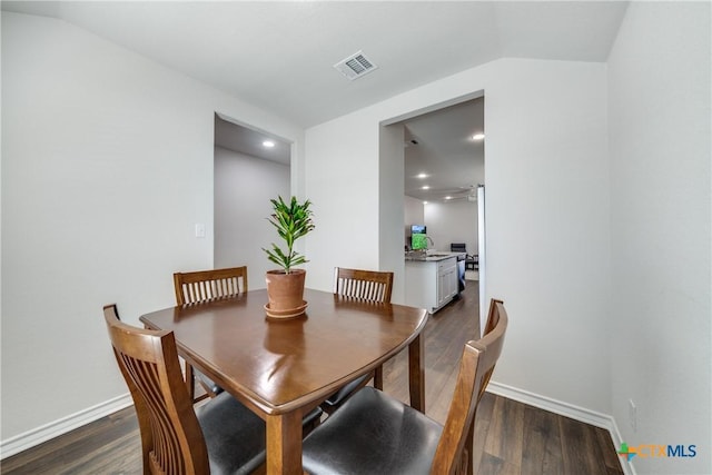 dining space with baseboards, visible vents, dark wood-type flooring, vaulted ceiling, and recessed lighting