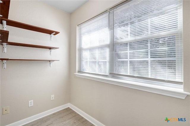 unfurnished room with wood-type flooring and a healthy amount of sunlight