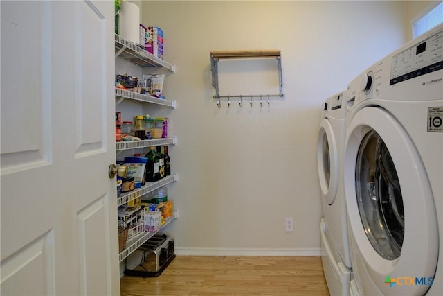 washroom with washer and clothes dryer and light hardwood / wood-style flooring