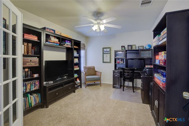 carpeted office space with ceiling fan