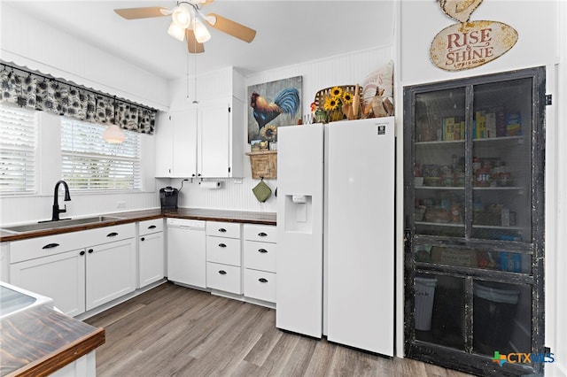 kitchen with hardwood / wood-style floors, sink, white cabinets, white appliances, and ceiling fan