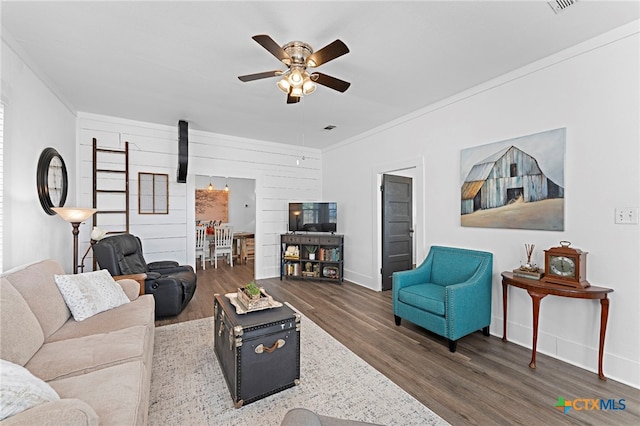 living room with ornamental molding, dark hardwood / wood-style flooring, and ceiling fan