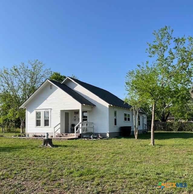 rear view of house featuring a yard
