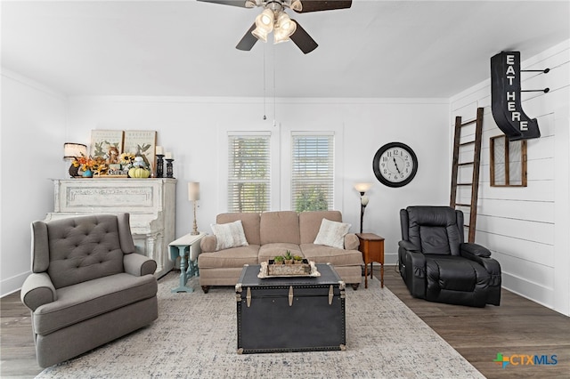 living room featuring ceiling fan, wood-type flooring, and ornamental molding