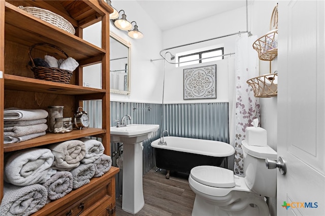 bathroom with toilet, hardwood / wood-style flooring, and a tub