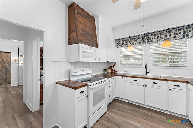 kitchen featuring sink, white appliances, white cabinets, pendant lighting, and dark hardwood / wood-style flooring