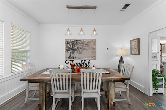 dining room featuring dark hardwood / wood-style flooring and crown molding