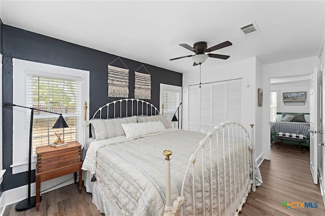 bedroom featuring dark hardwood / wood-style flooring, ceiling fan, and a closet