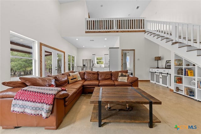 living room featuring french doors and a towering ceiling