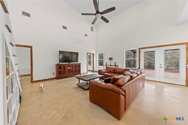 living room with a high ceiling, a wealth of natural light, french doors, and ceiling fan