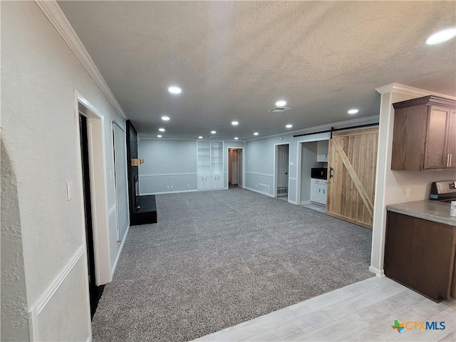 4106 Ermine Trl, Temple, TX 76504 - basement with a barn door, crown molding, a textured ceiling, recessed lighting, and baseboards