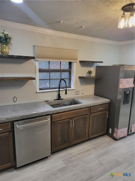 4106 Ermine Trl, Temple, TX 76504 - kitchen featuring appliances with stainless steel finishes, a sink, open shelves, dark brown cabinets, and crown molding