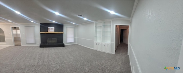 4106 Ermine Trl, Temple, TX 76504 - unfurnished living room with built in features, carpet flooring, a textured wall, and a large fireplace