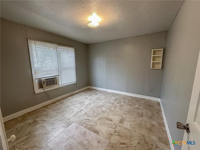 spare room featuring cooling unit and a textured ceiling