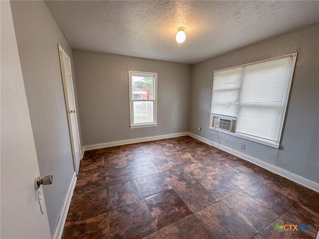 unfurnished room with cooling unit and a textured ceiling