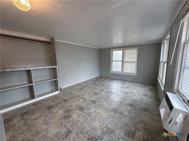 empty room with a textured ceiling and a wall unit AC