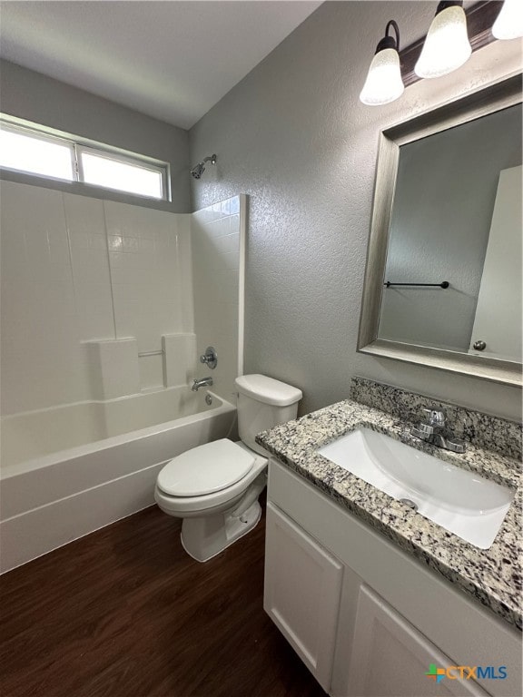 full bathroom featuring hardwood / wood-style floors, vanity, bathing tub / shower combination, and toilet