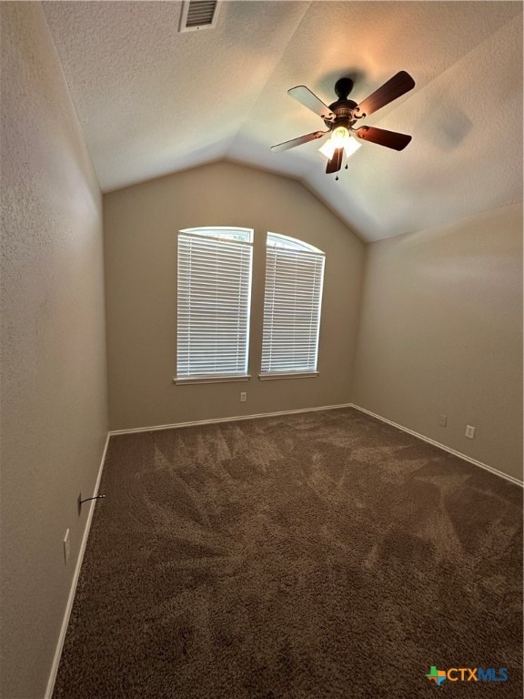 spare room featuring carpet flooring, a textured ceiling, ceiling fan, and vaulted ceiling