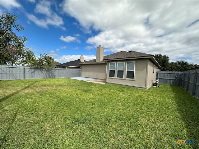 rear view of house with a lawn and a patio