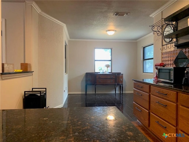 3002 Veterans Ave, Copperas Cove, TX 76522 - kitchen with stainless steel microwave, granite floors, crown molding, open shelves, and dark stone counters