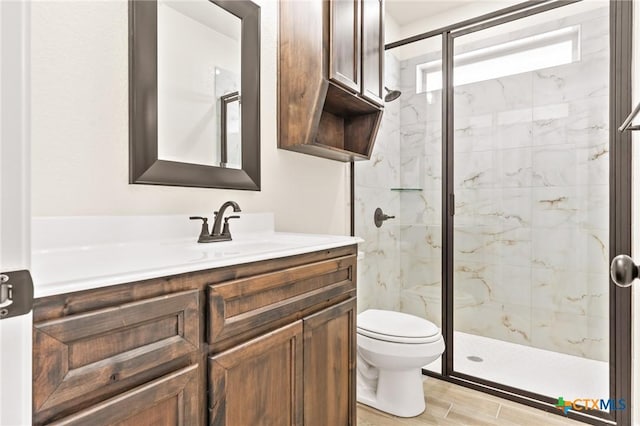 bathroom featuring hardwood / wood-style flooring, vanity, toilet, and walk in shower