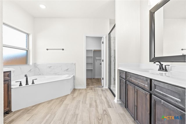 bathroom featuring hardwood / wood-style floors, vanity, and shower with separate bathtub