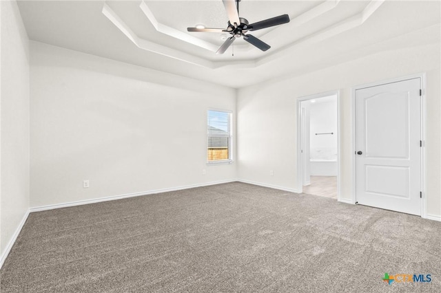 unfurnished room featuring ceiling fan, a raised ceiling, and carpet floors