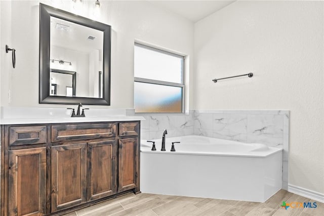 bathroom with vanity, hardwood / wood-style flooring, and a bathing tub