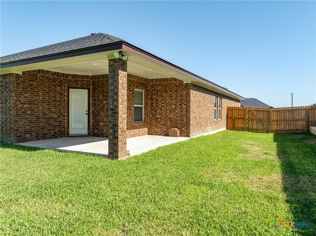 back of property with a yard and a patio