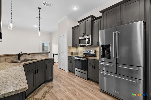 705 Juniper Dr, Troy, TX 76579 - kitchen featuring stainless steel appliances, light wood finished floors, ornamental molding, backsplash, and pendant lighting