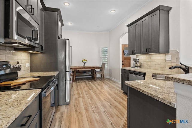 705 Juniper Dr, Troy, TX 76579 - kitchen featuring appliances with stainless steel finishes, light wood finished floors, crown molding, light stone countertops, and tasteful backsplash