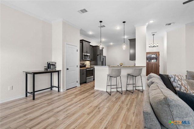 705 Juniper Dr, Troy, TX 76579 - kitchen featuring appliances with stainless steel finishes, open floor plan, a kitchen bar, ornamental molding, and light wood-style floors