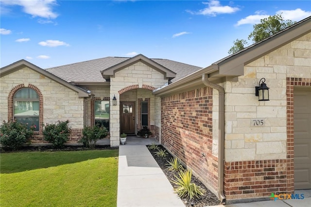 705 Juniper Dr, Troy, TX 76579 - entrance to property with stone siding, a yard, roof with shingles, brick siding, and a garage