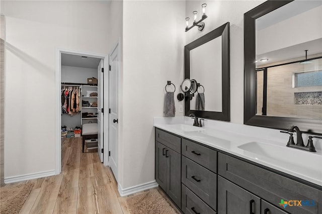 705 Juniper Dr, Troy, TX 76579 - bathroom with wood finished floors, double vanity, and a walk in closet