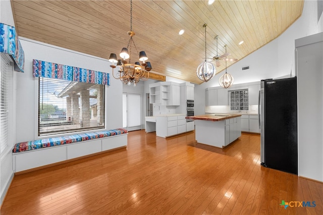 kitchen featuring a center island, white cabinets, hanging light fixtures, wooden ceiling, and appliances with stainless steel finishes