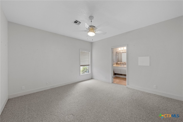 unfurnished bedroom with ensuite bath, light carpet, and ceiling fan