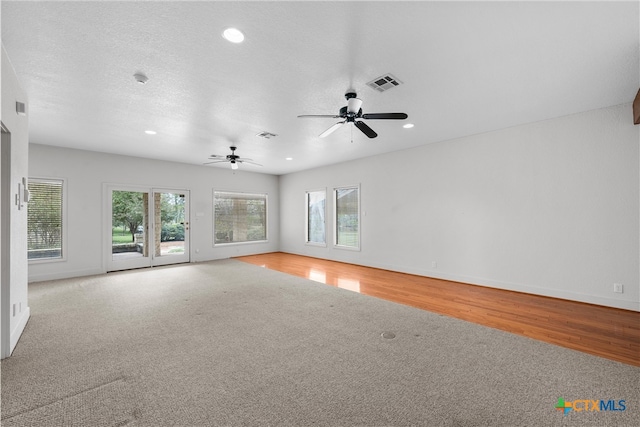 spare room with ceiling fan, a textured ceiling, a healthy amount of sunlight, and light wood-type flooring