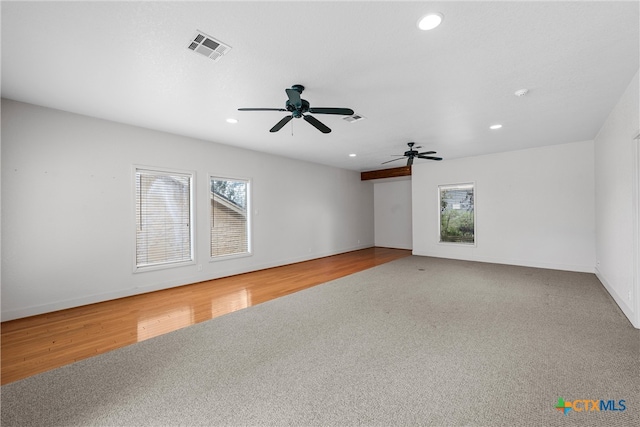 spare room featuring a wealth of natural light, hardwood / wood-style floors, and ceiling fan