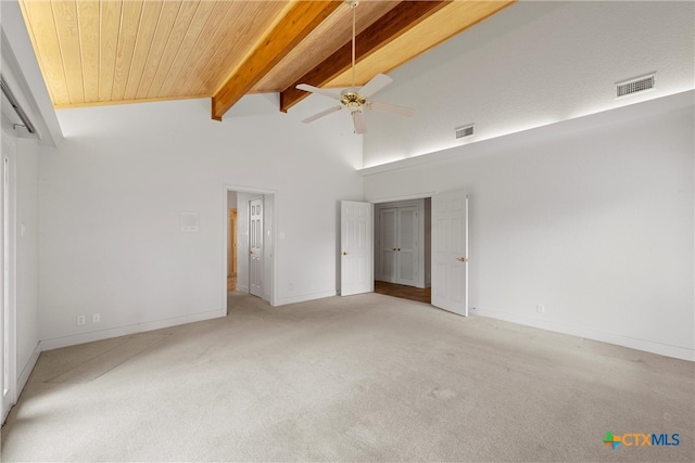 unfurnished bedroom with high vaulted ceiling, light carpet, ceiling fan, and beam ceiling