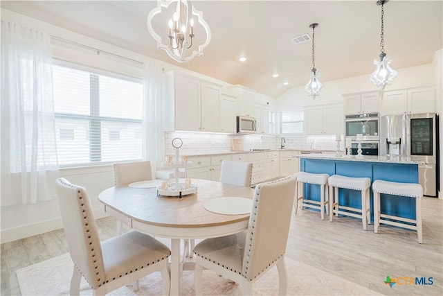 2306 Wooster St, Nolanville, TX 76559 - dining space with visible vents, a chandelier, light wood-style flooring, and vaulted ceiling