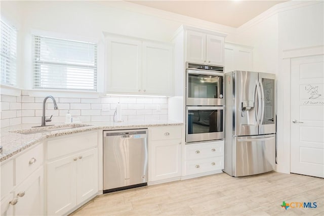 2306 Wooster St, Nolanville, TX 76559 - kitchen featuring light stone countertops, a sink, tasteful backsplash, white cabinetry, and appliances with stainless steel finishes