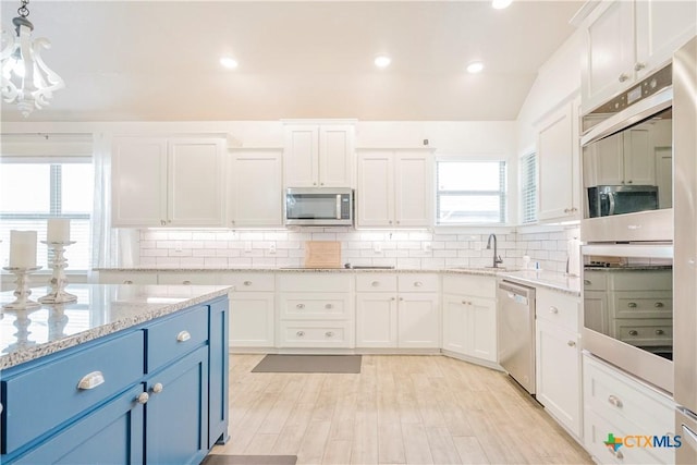 2306 Wooster St, Nolanville, TX 76559 - kitchen featuring blue cabinets, tasteful backsplash, appliances with stainless steel finishes, a sink, and white cabinetry