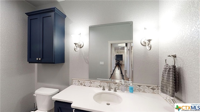 bathroom featuring decorative backsplash, vanity, and toilet