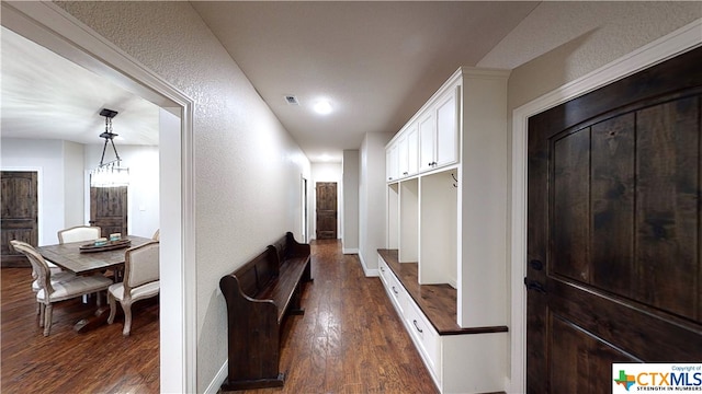 hallway featuring a notable chandelier and dark hardwood / wood-style floors